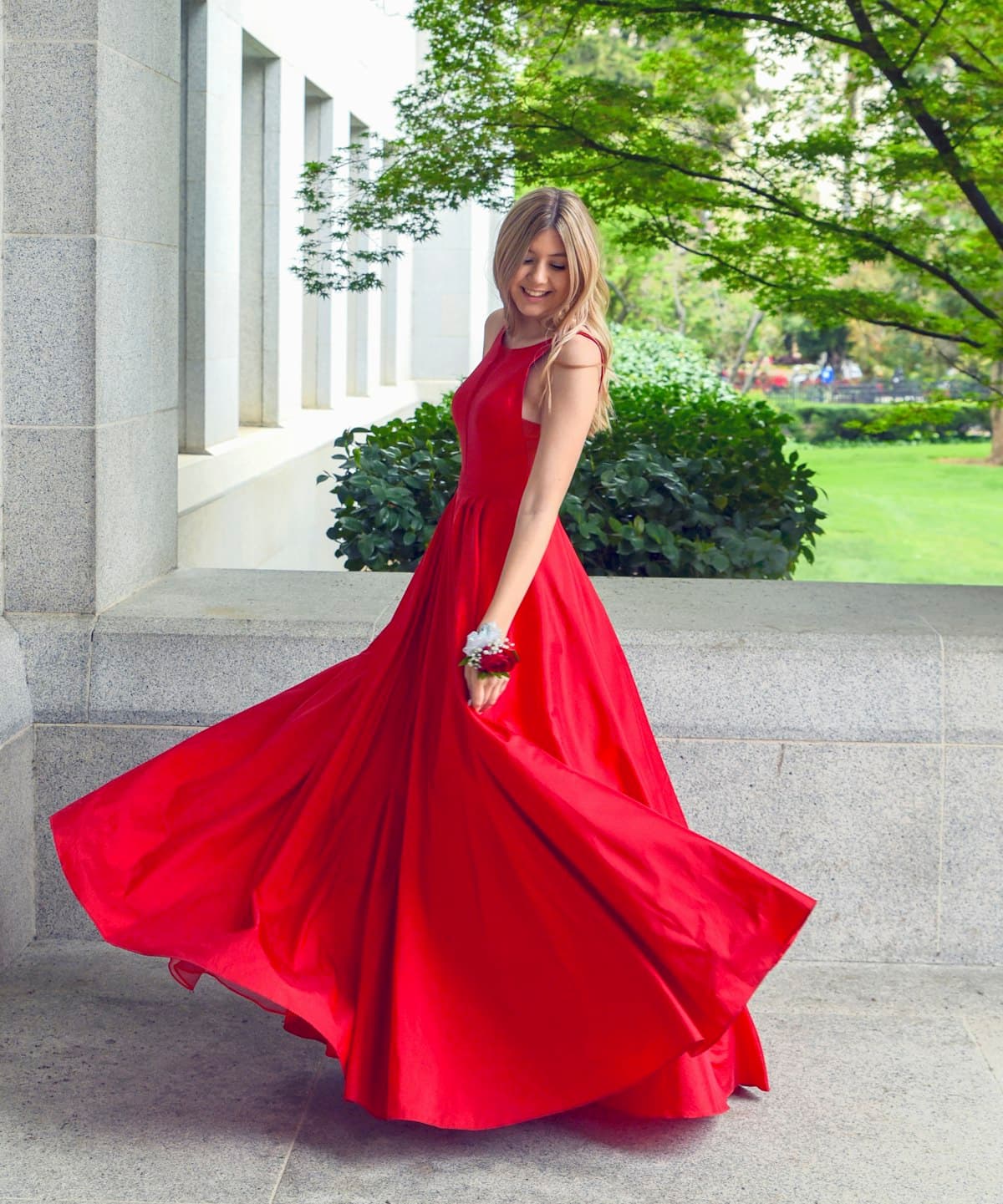 Woman wearing a flowing red evening dress against a dark backdrop
